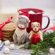 Handmade felt Dog with Gift and Santa Cat ornaments from Craftspring—displayed with a mug of hot cocoa and cookies, perfect for festive pet lovers and cozy holiday gifting, ethically crafted by artisans using sustainable wool.
