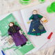 Craftspring’s handmade felt Ada Lovelace and Marie Curie Christmas ornaments displayed together on a notebook, surrounded by science tools, books, and beakers—featuring intricate beaded and embroidered details, perfect for thoughtful holiday gifting, ethically crafted by artisans using sustainable wool.