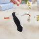 Handmade felt New Baby Stork ornament from Craftspring, featuring a stork carrying a bundle with delicate beaded and embroidered details—displayed hanging surrounded by flowers and presents, perfect for nursery decor and thoughtful baby shower gifting, ethically crafted by artisans using sustainable wool.