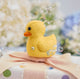 Handmade felt Rubber Duck ornament from Craftspring, featuring embroidered and beaded soap bubbles—displayed on a wrapped gift surrounded by bubbles, perfect for nursery decor and thoughtful baby shower gifting, ethically crafted by artisans using sustainable wool.