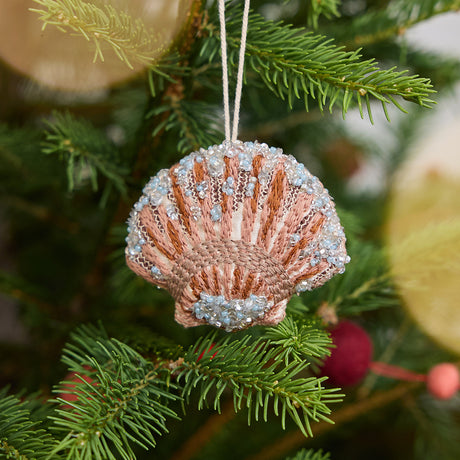 Craftspring’s Scallop Shell Ornament displayed on a Christmas tree — made of satin with intricate beaded and embroidered details, adding coastal holiday charm and gifting warmth, ethically crafted by artisans.