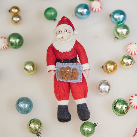 Felt Santa Claus figurine with a background of colorful Christmas ornaments
