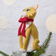Handmade felt Orange Cat Tree Topper from Craftspring, wearing a festive red bow—shown from the side perched atop a Christmas tree, bringing playful holiday cheer and purr-fect gifting joy, ethically crafted by artisans using sustainable wool.