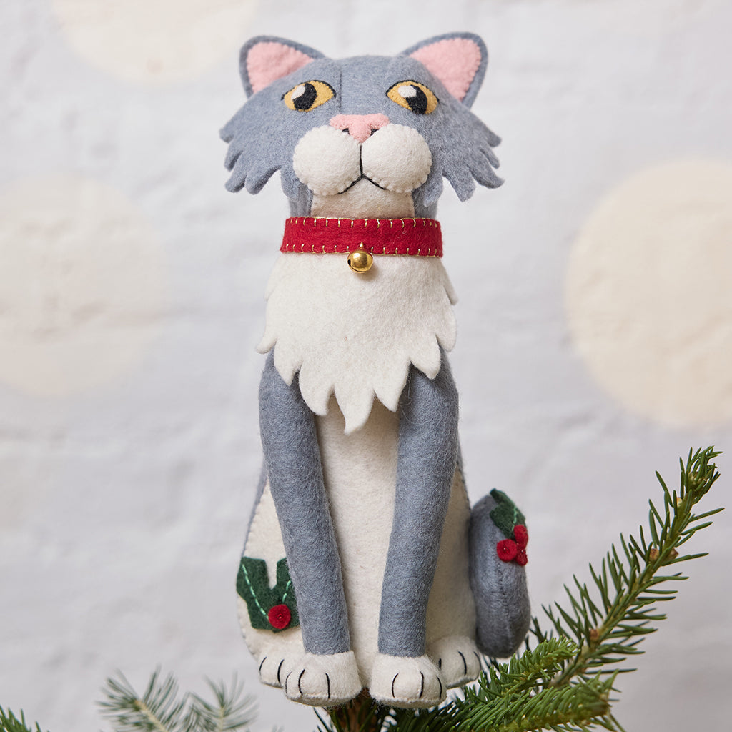 Handmade felt Gray Cat Tree Topper from Craftspring, featuring holly accents and a red collar with a bell—displayed on top of a Christmas tree, perfect for festive feline lovers and whimsical holiday decorating, ethically crafted by artisans using sustainable wool.