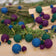 Handmade felt Jewel Tone Ball Garland from Craftspring, featuring deep jewel-tone felt balls strung on a gold ribbon—displayed among evergreen branches, perfect for adding rich, festive color and heirloom-quality holiday charm, ethically crafted by artisans using sustainable wool.