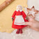 Capture a moment of sweet holiday joy, holding a Mrs. Clause ornament while baking gingerbread.