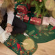 A girl sits under the Christmas tree on Craftspring’s Woodland Tree Skirt, reaching into Craftspring’s Woodland Stocking — a joyful holiday moment filled with cozy magic and gifting, ethically crafted by artisans using sustainable wool.