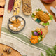 Craftspring’s handmade felt Cornucopia, Turkey Dinner, and Pumpkin Pie ornaments — a crocheted raffia cornucopia filled with felt and beaded vegetables and fruit, a roasted turkey with autumn sides, and a plump pumpkin pie, displayed on a harvest table with autumn corn for a festive Thanksgiving scene, perfect for holiday decorating or gifting, ethically crafted by artisans using sustainable wool.