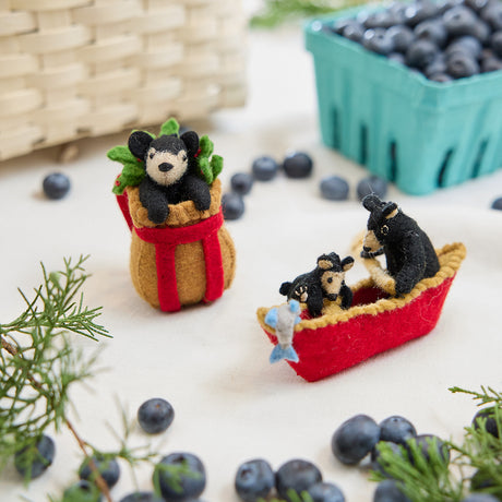 Craftspring’s handmade felt Adirondack Basket with Black Bear Cub and Bears in a Canoe ornaments — a playful black bear cub peeking from a cozy brown basket and a mama bear paddling a canoe with a cub climbing over the side, displayed together for a whimsical holiday scene, perfect for Christmas decorating or gifting, ethically crafted by artisans using sustainable wool.