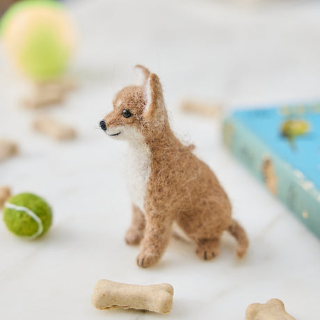 Craftspring’s needle-felted Chihuahua Ornament with big ears and a cute face, displayed among dog treats and toys — a playful and charming holiday decoration, perfect for gifting, ethically crafted by artisans using sustainable wool.
