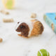 Craftspring’s Guinea Pig Ornament displayed among pet toys—an adorable needle-felted design that adds cozy holiday cheer and makes a delightful, heirloom-quality gift, ethically crafted by artisans using sustainable wool.