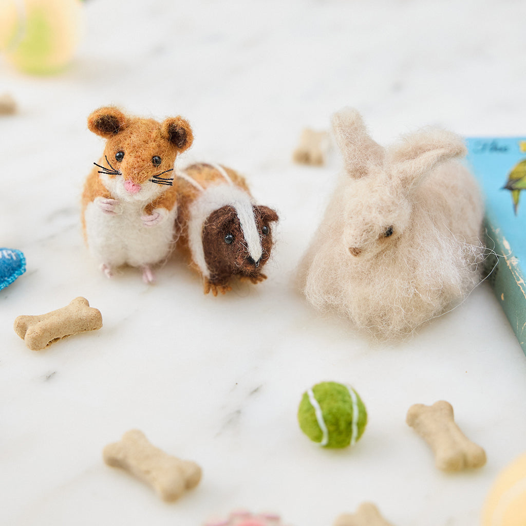 Craftspring’s handmade felt Hamster, Guinea Pig, and Angora Rabbit ornaments displayed among pet toys—needle-felted and adorable, bringing playful holiday joy and gifting warmth, ethically crafted by artisans using sustainable wool.