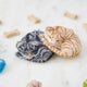 Craftspring’s needle-felted Sleepy Orange Cat and Sleepy Gray Cat ornaments displayed among pet treats and toys — both with cute faces, whiskers, and charming details, creating a playful and festive holiday scene, perfect for gifting, ethically crafted by artisans using sustainable wool.