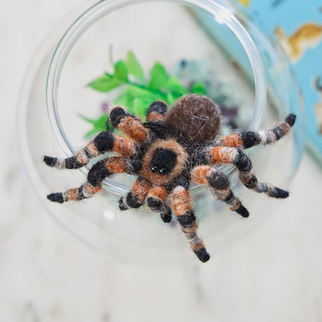 Craftspring’s handmade needle-felted Tarantula Ornament with hairy legs, displayed crawling out of a fish bowl for a playful and spooky touch—unique decor for Halloween or a quirky holiday gift, ethically crafted by artisans using sustainable wool.