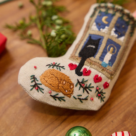 Craftspring’s handmade linen Holiday Cats Mini Stocking ornament — close-up detail of one of the embroidered cats curled up on a rug, highlighting the intricate beaded and embroidered holiday scene, perfect for Christmas decorating or gifting, ethically crafted by artisans using sustainable materials.