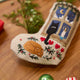 Craftspring’s handmade linen Holiday Cats Mini Stocking ornament — close-up detail of one of the embroidered cats curled up on a rug, highlighting the intricate beaded and embroidered holiday scene, perfect for Christmas decorating or gifting, ethically crafted by artisans using sustainable materials.