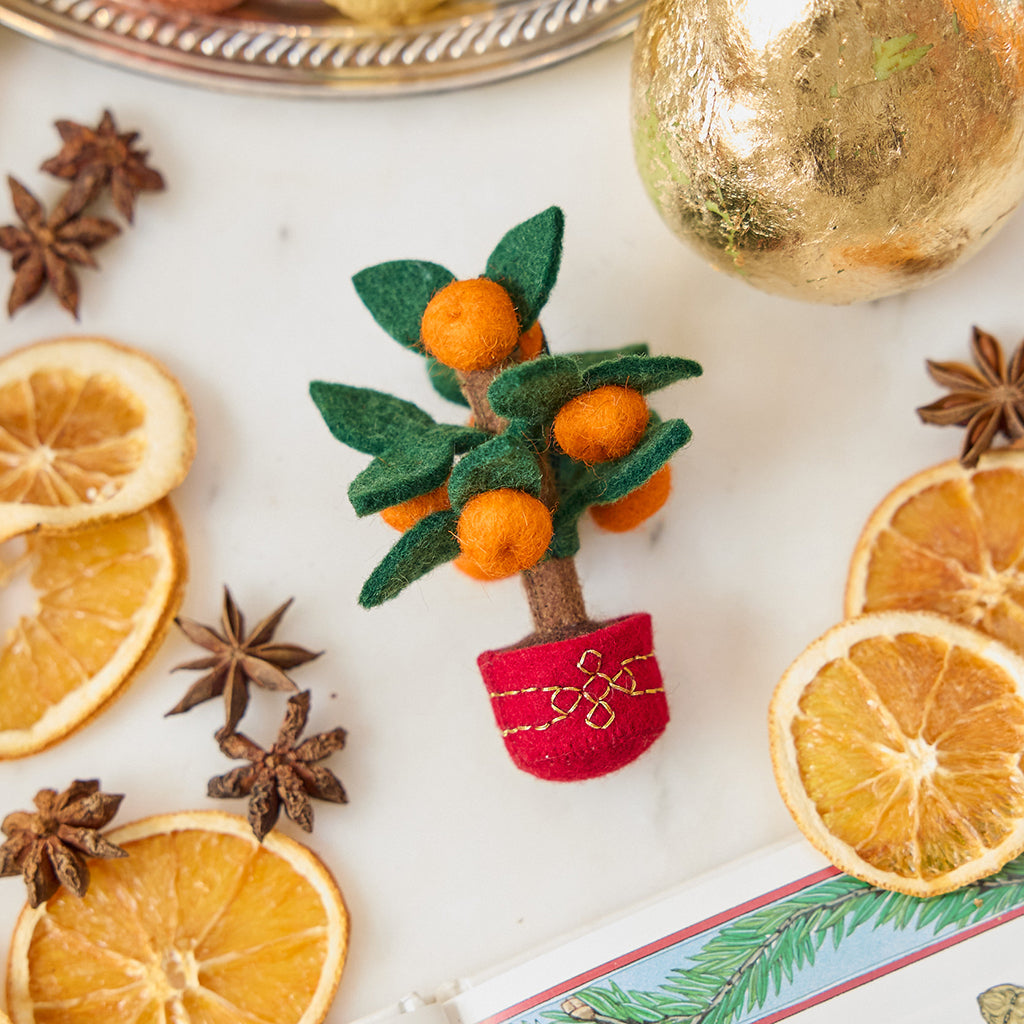 Craftspring’s Clementine Tree Ornament styled with dried orange slices and star anise seed — handmade felt holiday decor in a red embroidered pot with clementines, evoking warm traditions of Lunar New Year and Christmas, ethically crafted by artisans using sustainable wool.