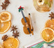 Craftspring’s Cello Ornament displayed with dried orange slices and star anise — handmade felt heirloom with festive holly, beaded and embroidered details, ethically crafted by artisans using sustainable wool.
