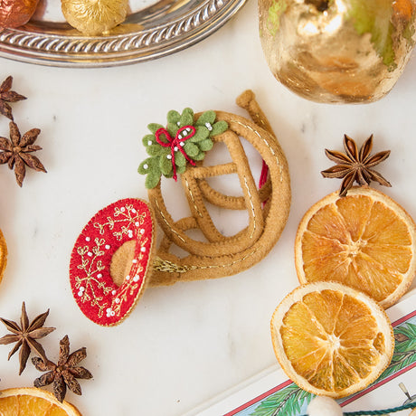 French Horn Ornament from Craftspring styled with dried orange slices and star anise — handmade felt ornament with golden embroidery, beading, and mistletoe, perfect for Christmas gifting, ethically crafted by artisans using sustainable wool.