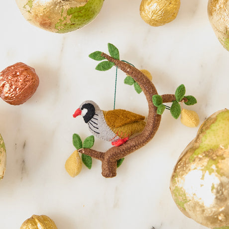 Craftspring’s Partridge in a Pear Tree Ornament — partridge with three dangling pears in a festive tree, displayed with golden walnuts and pears for a warm Christmas scene, ethically crafted by artisans using sustainable wool.