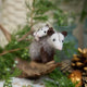 Craftspring’s Opossum Mom with Babies Ornament — handmade with three tiny babies with cute faces and pink tails — perched on a stick among evergreens, capturing whimsical holiday charm and heirloom-quality Christmas cheer, ethically crafted by artisans using sustainable wool.