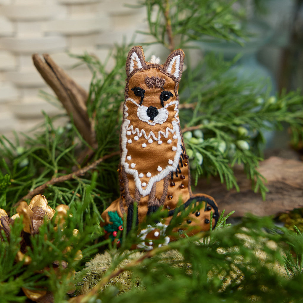 Craftspring’s handmade satin Fox Beaded Ornament — featuring intricate beaded and embroidered details, displayed nestled among evergreens for a cozy woodland holiday scene, perfect for Christmas decorating or gifting, ethically crafted by artisans using sustainable materials.