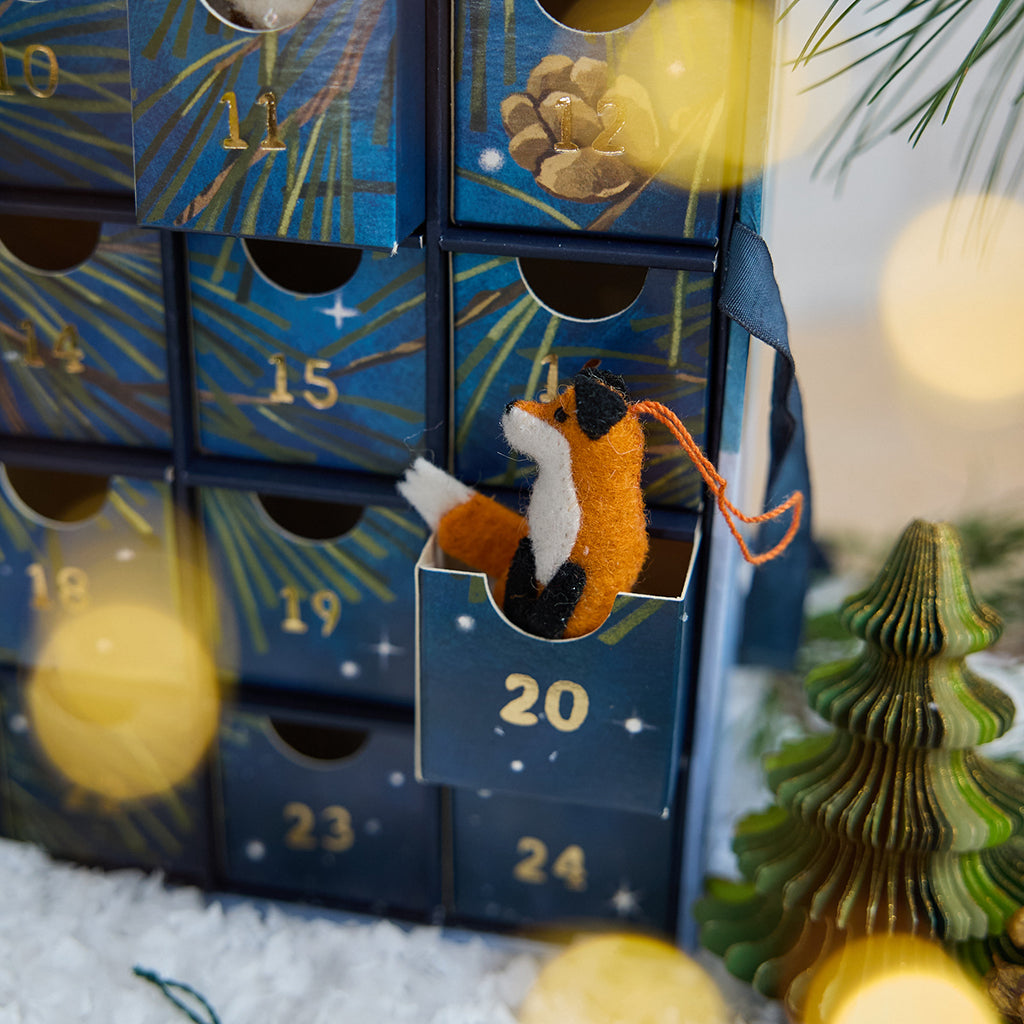 Craftspring’s handmade Woodland Minis Advent Calendar — close-up of an open drawer with a mini fox ornament peeking out, highlighting the charming woodland Christmas details, ethically crafted by artisans using sustainable wool.