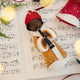 Caroler Playing the Clarinet Ornament from Craftspring — handmade felt holiday ornament with sweet facial details, intricate applique, and embroidered snow, hanging on a Christmas tree, ethically crafted by artisans using sustainable wool.
