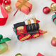 Craftspring’s Steam Engine Train Ornament — felt black and red train with gold embroidery and beading, fluffy steam, and a wreath on the back — styled among holiday baubles and mini presents, evoking festive warmth, playful Christmas cheer, and heirloom-quality charm, ethically crafted by artisans using sustainable wool.