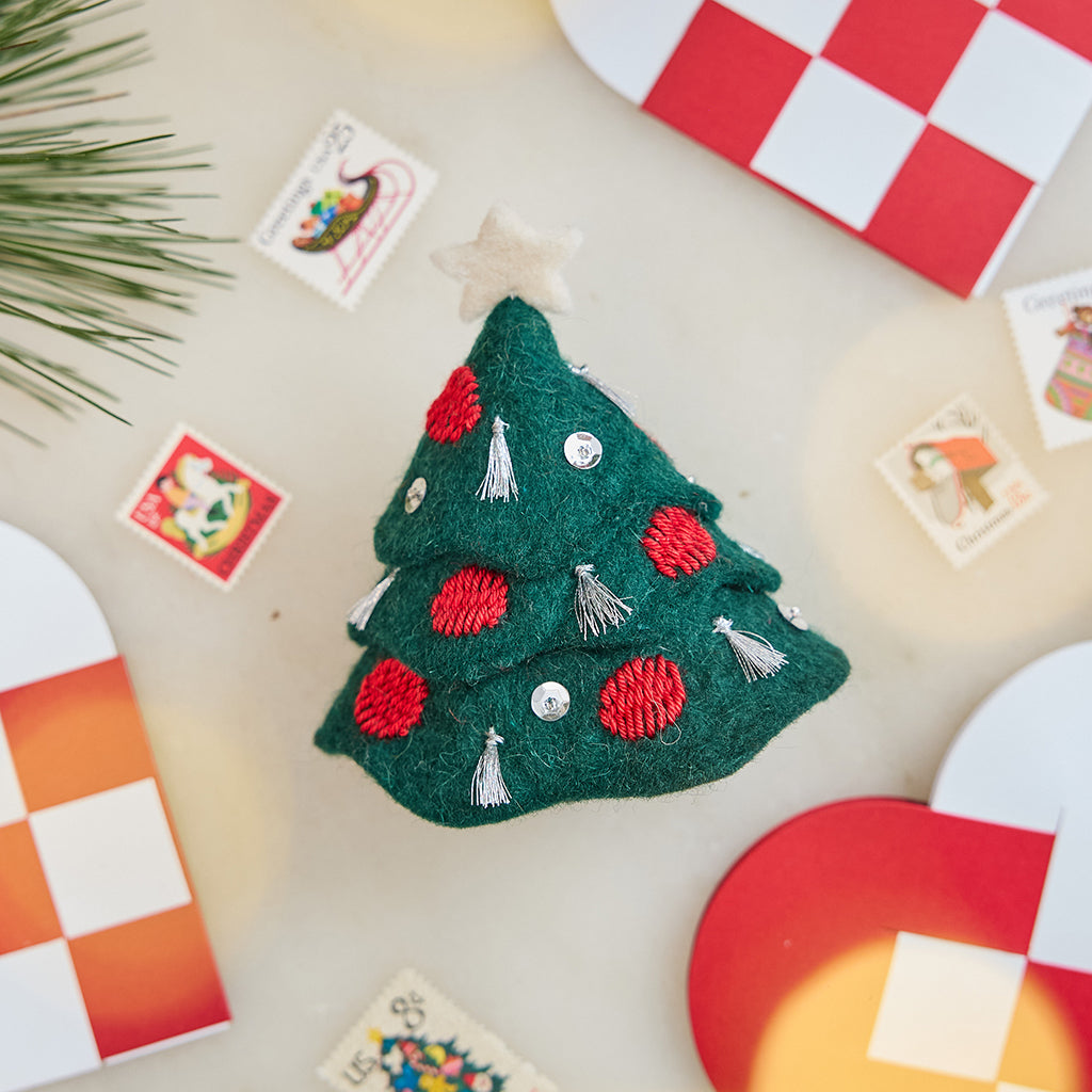 Craftspring’s Tinsel Tree — felt tree with silver tinsel tassels, embroidered baubles, beaded ornaments, and a star on top — styled alongside Danish heart baskets and Christmas vintage stamps, capturing whimsical holiday charm, festive warmth, and heirloom-quality gifting, ethically crafted by artisans using sustainable wool.