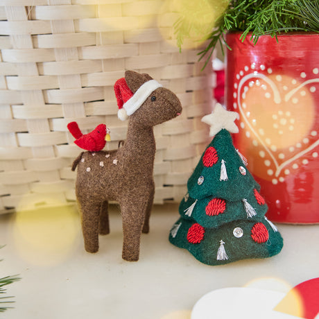 Craftspring’s Santa Deer with Bird Friend Ornament and Tinsel Tree — felt deer with a bird friend and felt tree with silver tinsel tassels, embroidered baubles, beaded ornaments, and a star on top — displayed together in front of a basket, evoking whimsical holiday charm, festive warmth, and heirloom-quality Christmas gifting, ethically crafted by artisans using sustainable wool.