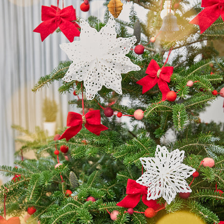 Craftspring’s Paper Snowflakes Christmas Ornaments — Set of 2, large white snowflakes with intricate cutout patterns — displayed on a Christmas tree, adding festive and elegant holiday decoration, ethically handmade by artisans from recycled cotton waste.