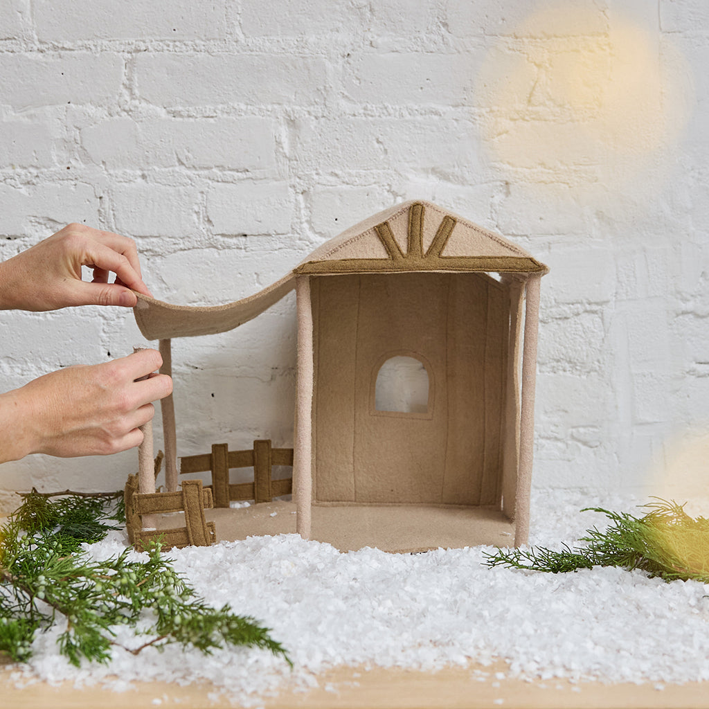Hands demonstrating velcro connections of the Nativity Barn — shows easy assembly and secure display for Craftspring’s Holy Night Nativity Scene, ethically crafted by artisans using sustainable wool.