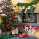 Craftspring’s Woodland Tree Skirt displayed under a Christmas tree decorated with Craftspring ornaments, next to a fireplace with Woodland Stockings and many presents — a festive holiday scene full of warmth and gifting joy, ethically crafted by artisans using sustainable wool.