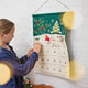 Craftspring’s Woodland Advent Calendar with a girl looking into one of the pockets — the felt calendar features embroidered, appliqué, and beaded woodland details, creating a festive holiday moment full of wonder and gifting joy, ethically crafted by artisans using sustainable wool.