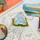 Craftspring’s handmade felt Home Under the Stars Tent ornament — applique and embroidered mountains with the Big Dipper on the side and a mini felt mattress inside the tent, displayed on a trail map for an adventurous holiday scene, perfect for Christmas decorating or gifting, ethically crafted by artisans using sustainable wool.