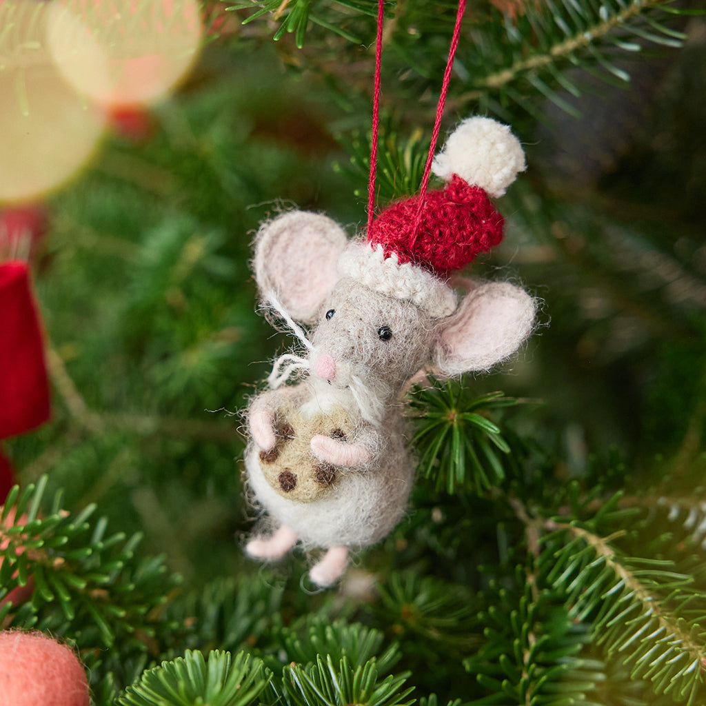 Craftspring’s Santa Mouse with Cookie Ornament displayed on a Christmas tree — needle felted mouse with a cute face and whiskers, wearing a knitted Santa hat and holding a cookie, adding whimsical holiday charm and festive warmth — heirloom-quality Christmas decor, ethically crafted by artisans using sustainable wool.