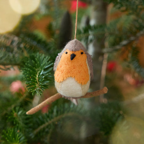 Craftspring’s European Robin ornament — featuring delicate beaded and embroidered details, displayed on a Christmas tree for a festive woodland holiday scene, ethically crafted by artisans using sustainable wool.