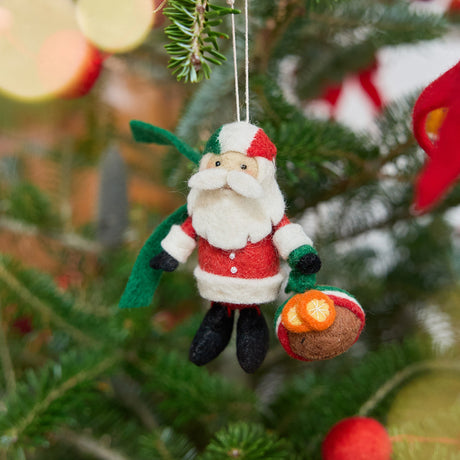 Craftspring’s Italian Santa ornament — featuring a cute Santa holding a panettone and wearing a helmet in Italian flag colors, displayed on a Christmas tree for a festive holiday scene, ethically crafted by artisans using sustainable wool.