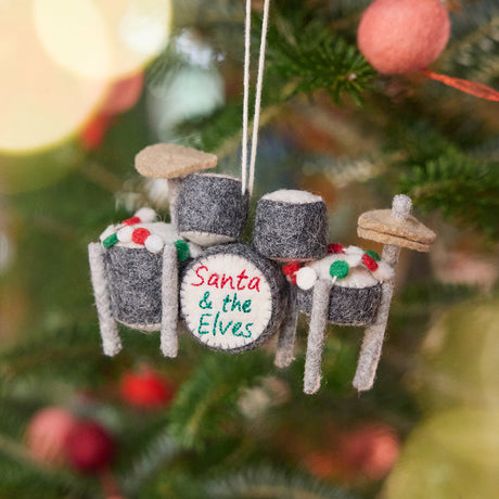 Christmas Drum Set Ornament from Craftspring displayed on a Christmas tree — handmade felt holiday decor with embroidered “Santa and the Elves” band name and intricate garland details, heirloom-quality ornament ethically crafted by artisans using sustainable wool.
