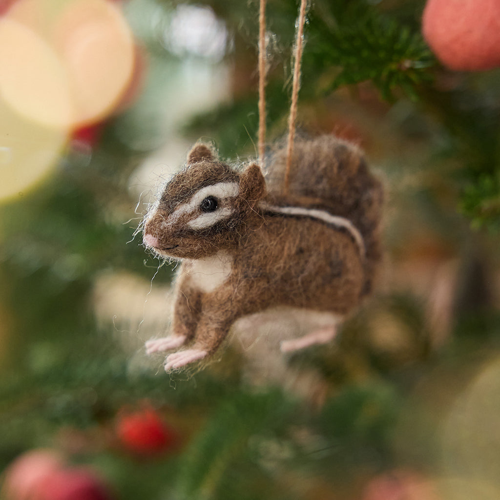 Handmade felt Fuzzy Chipmunk ornament from Craftspring hanging on a Christmas tree — needle-felted with an adorable face and stripes along its back, heirloom-quality holiday decor ethically crafted by artisans using sustainable wool.