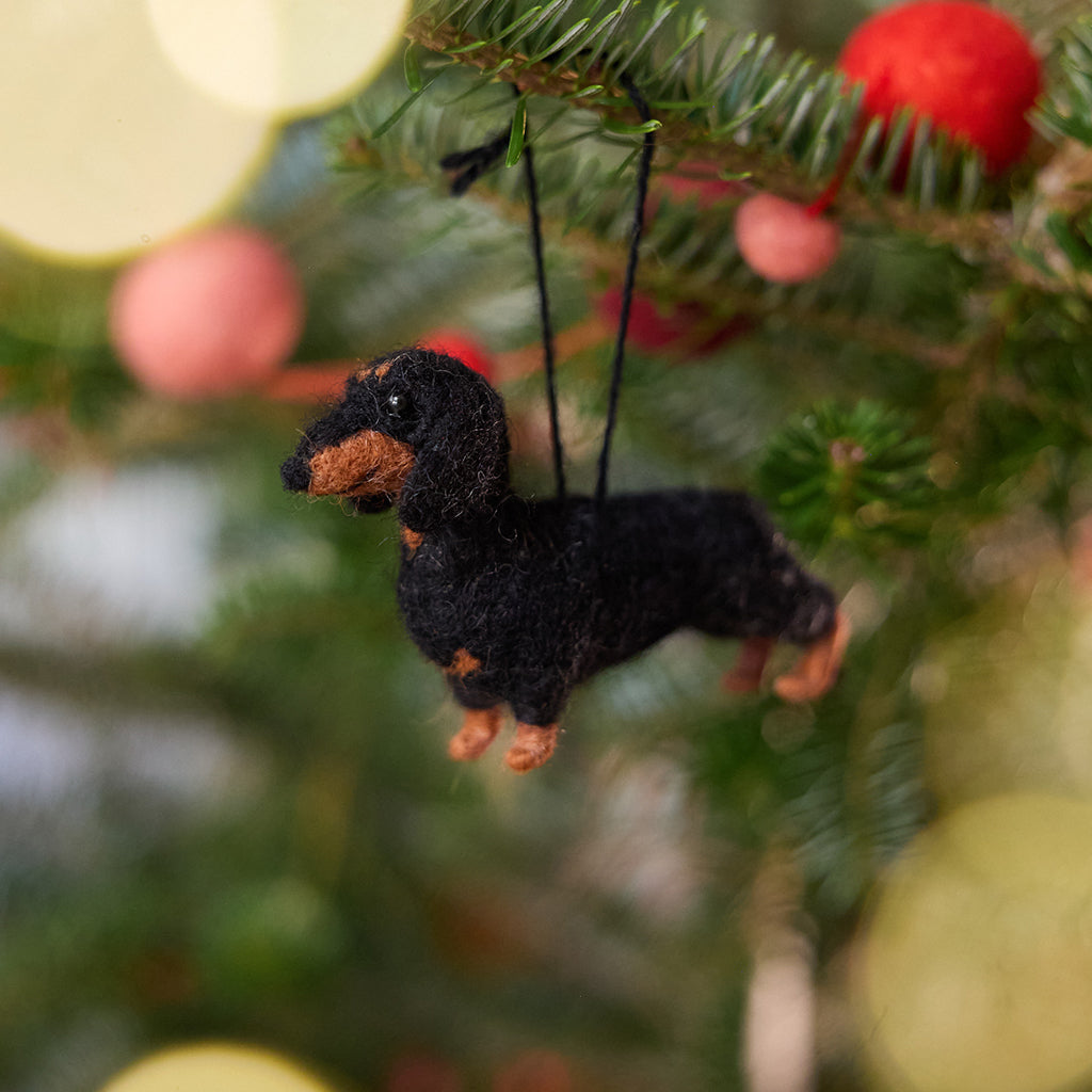 Craftspring’s Dachshund Ornament displayed on a Christmas tree—needle-felted with short legs and a cute face, adding playful holiday warmth and gifting charm, ethically crafted by artisans using sustainable wool.