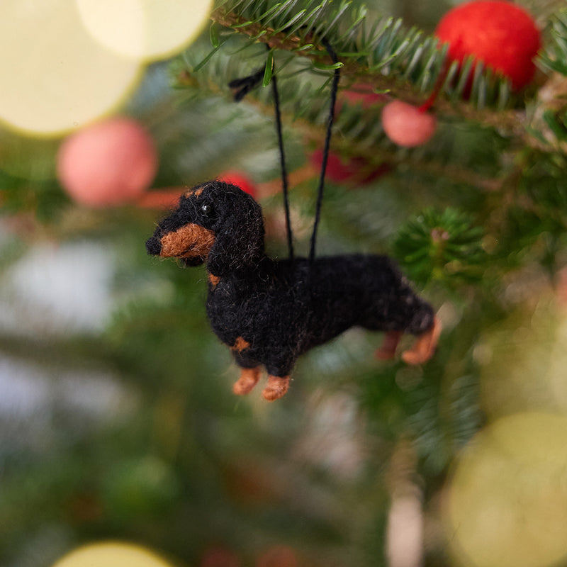 Craftspring’s Dachshund Ornament displayed on a Christmas tree—needle-felted with short legs and a cute face, adding playful holiday warmth and gifting charm, ethically crafted by artisans using sustainable wool.