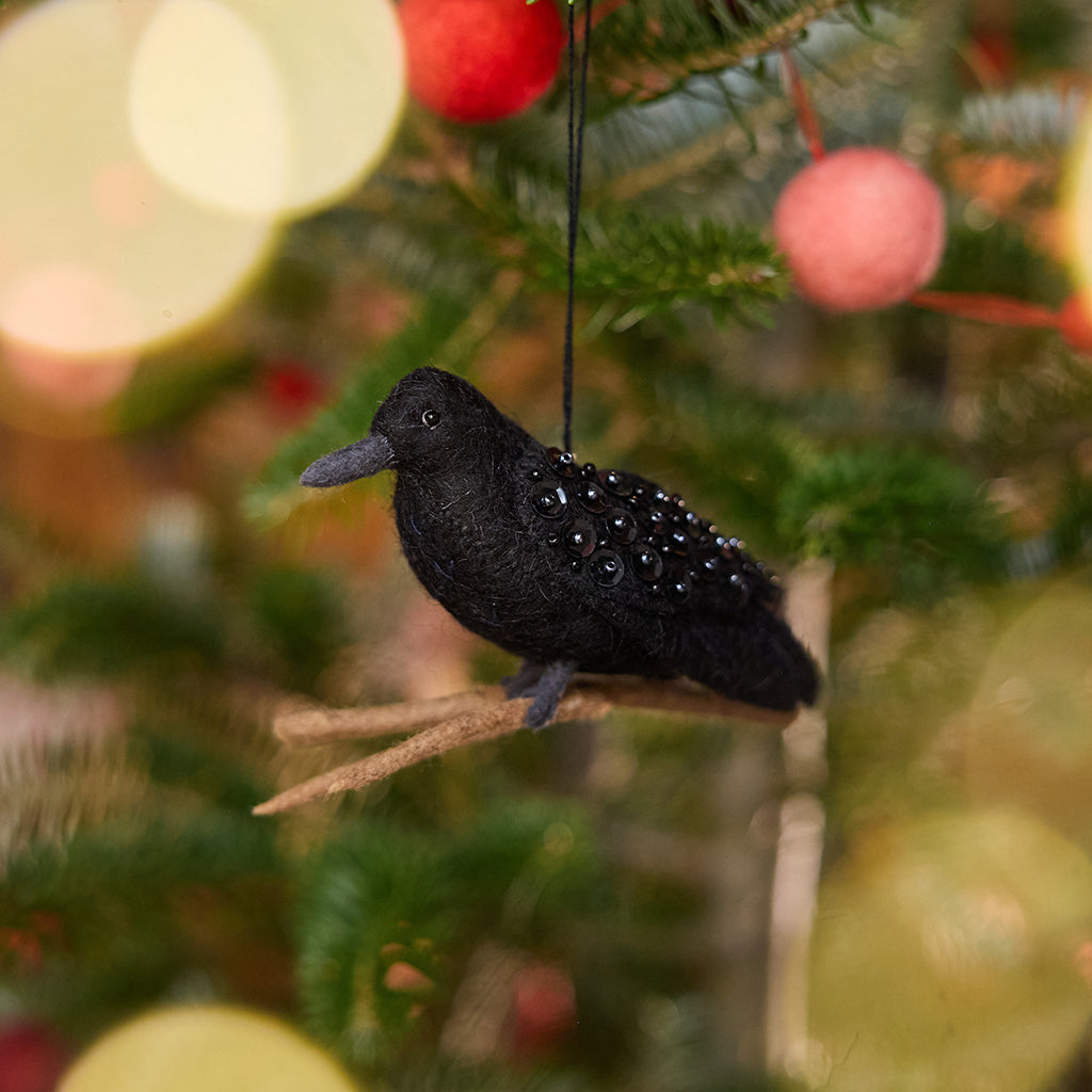 Craftspring’s Crow Ornament displayed on a Christmas tree — felt ornament of a crow perched on a branch with intricate beaded wings, perfect for Halloween, harvest, and holiday gifting, ethically crafted by artisans using sustainable wool.