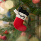 Craftspring’s Naughty Stocking with Coal Ornament displayed on a Christmas tree — felt red stocking filled with felt coal and beads, embroidered “naughty,” adding playful holiday charm and festive warmth — heirloom-quality Christmas decor, ethically crafted by artisans using sustainable wool.