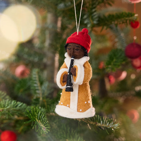 Caroler Playing the Clarinet Ornament from Craftspring — handmade felt holiday ornament with sweet facial details, intricate applique, and embroidered snow, hanging on a Christmas tree, ethically crafted by artisans using sustainable wool.