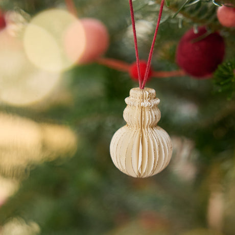 Craftspring’s snowman honeycomb paper mini ornament with gold sparkly edges displayed on a Christmas tree — handmade by artisans from recycled cotton waste.