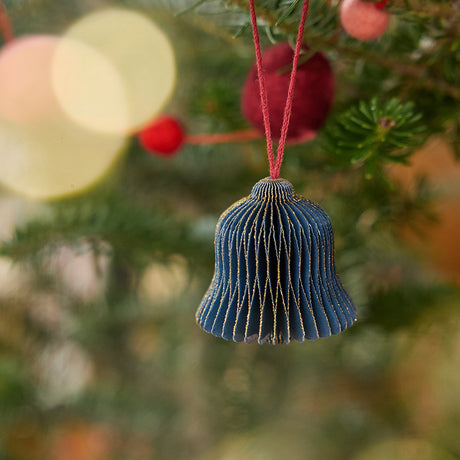 Craftspring’s bell honeycomb paper mini ornament with gold sparkly edges displayed on a Christmas tree — handmade by artisans from recycled cotton waste.