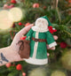 Craftspring’s Emerald Santa Mini Tree Topper displayed in front of a Christmas tree — felt Santa wears a green cloak with beaded details, holds a sack of presents, and has a bird on his shoulder, adding sweet, vintage-style charm — heirloom-quality Christmas decor, ethically crafted by artisans using sustainable wool.