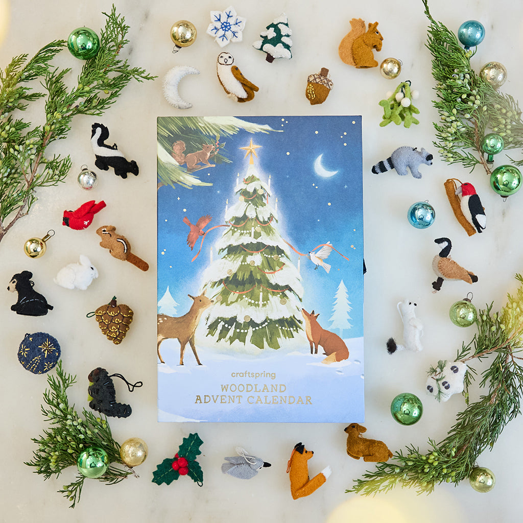 Craftspring’s Woodland Minis Advent Calendar with 24 mini woodland ornaments — featuring intricate embroidered and beaded details of animals, plants, the moon, and more, perfect for adding festive woodland charm to holiday decorating or gifting, ethically crafted by artisans using sustainable wool.